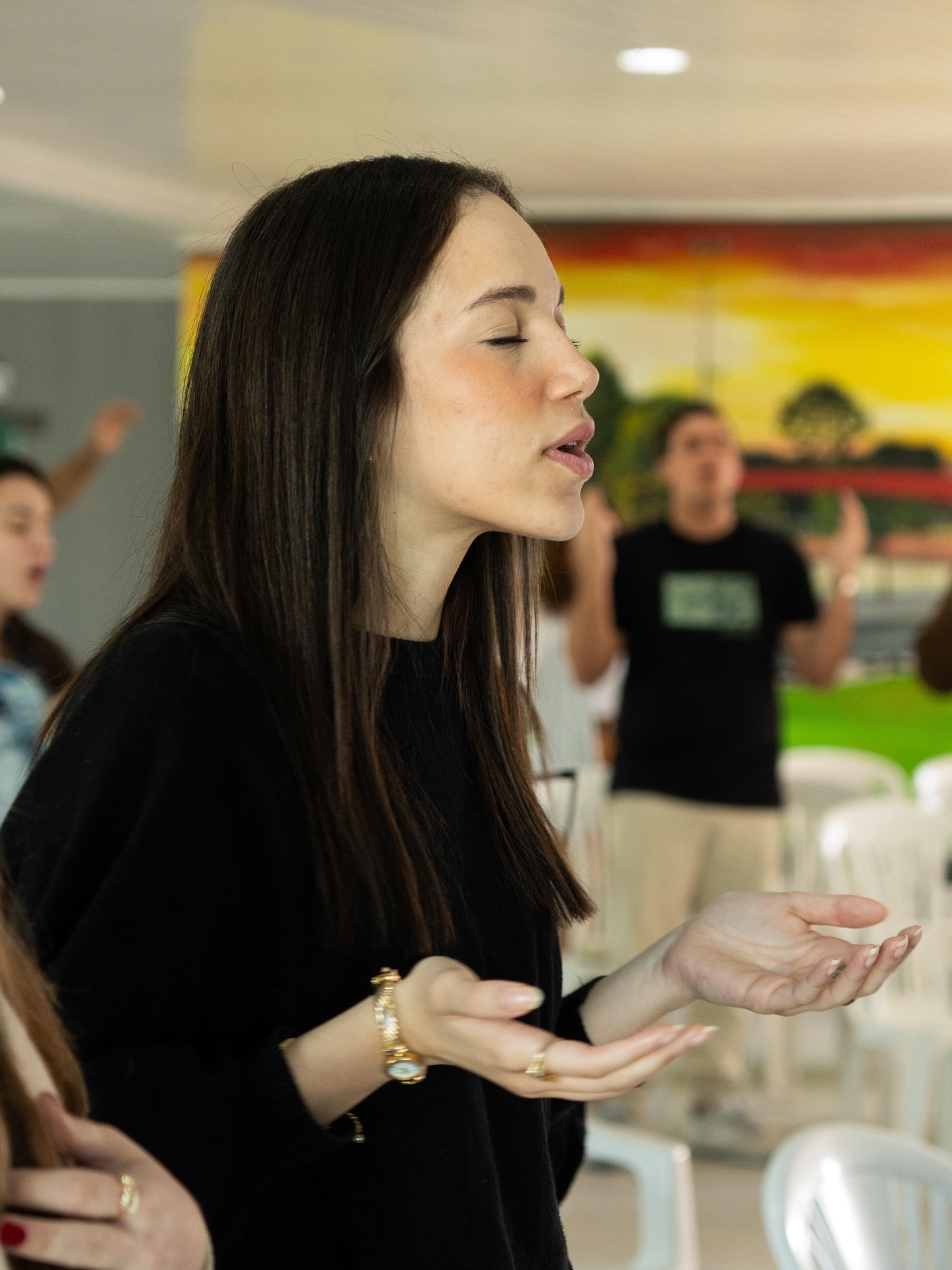 Uma jovem adorando de olhos fechados no culto
