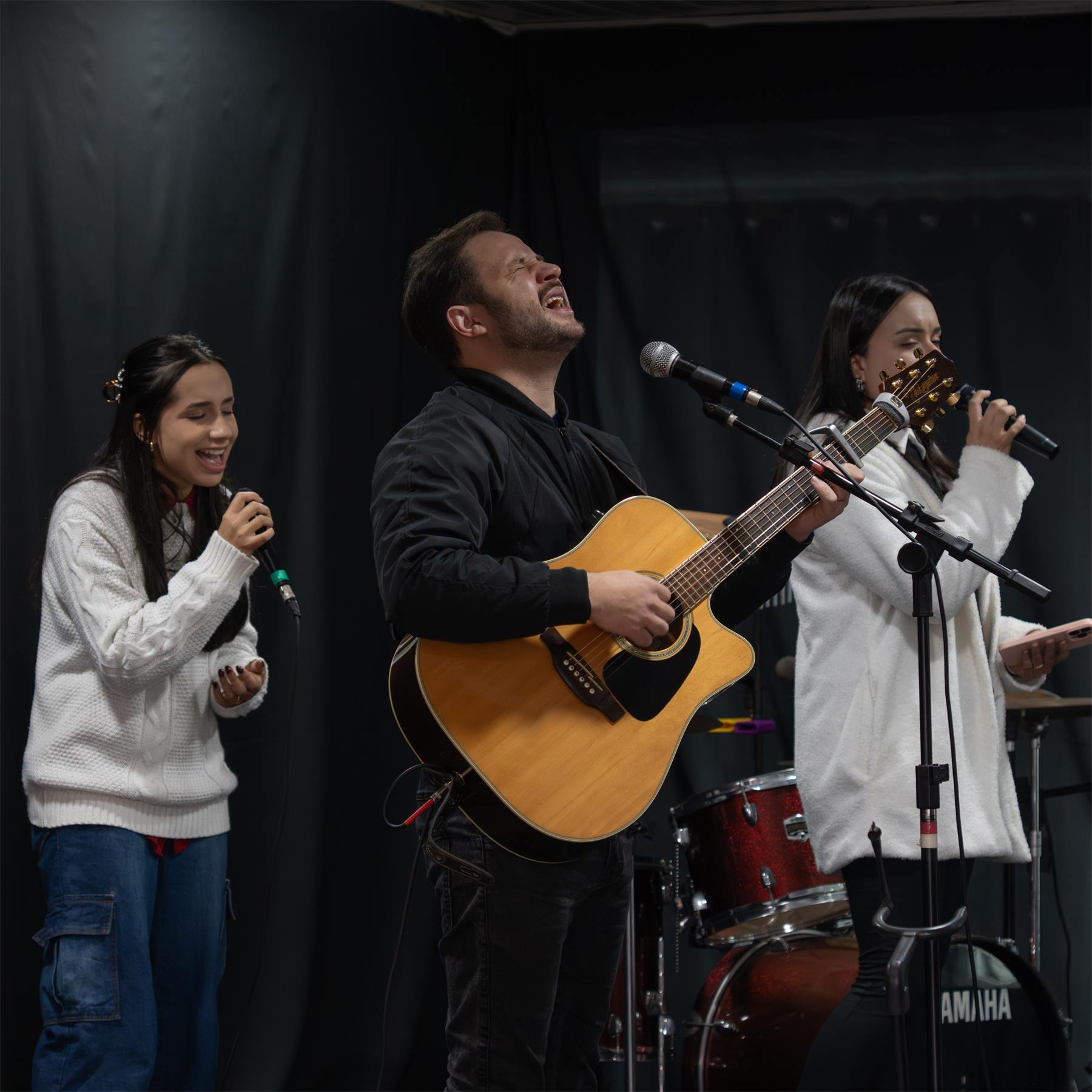 Equipe de louvor cantando e tocando violão